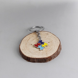 Detailed macro view of four-piece puzzle best friends metal keychain with colorful enamel