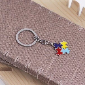Detailed close-up of a silver puzzle piece keychain with vibrant red yellow and blue colors