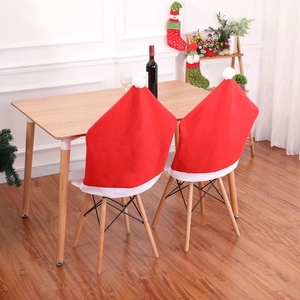 Close-up of red non-woven Christmas hat chair covers set on a wooden dining chair
