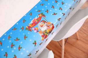 Detail of blue PVC Christmas tablecloth with Santa Claus motifs and snowflake prints