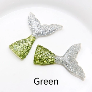 Close-up of resin mermaid tail accessories in green with detailed scale texture