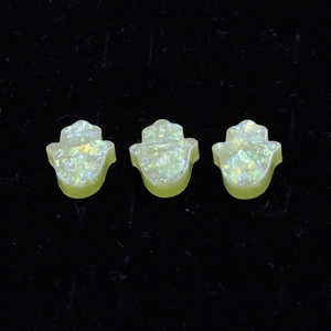 Macro detail of yellow-green synthetic opal Hamsa hand charms for DIY jewelry making