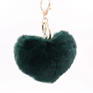 Detailed view of dark green heart-shaped plush keychain with gold metal hardware and ring