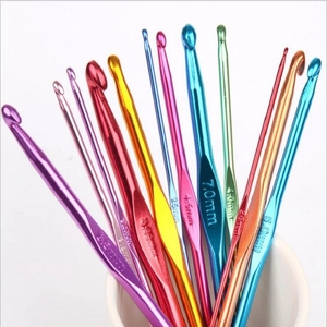 Close-up of colorful metal crochet hooks in a cup showing laser-engraved metric sizes