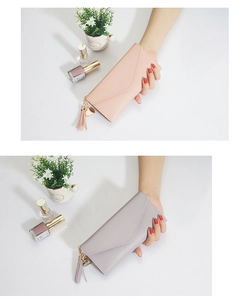 Detail of pink and purple long wallets with heart charms and elegant tassel accents