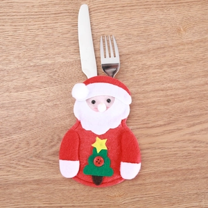 Detail of Santa Claus felt cutlery holder with green tree pattern on a wooden table