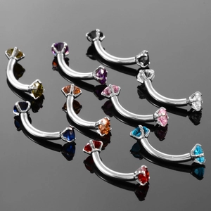 Macro shot of curved stainless steel eyebrow rings with multi-color zircon stones