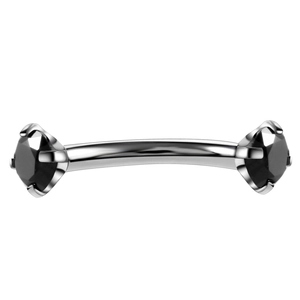 Detailed macro view of curved stainless steel eyebrow piercing with black zircon stones