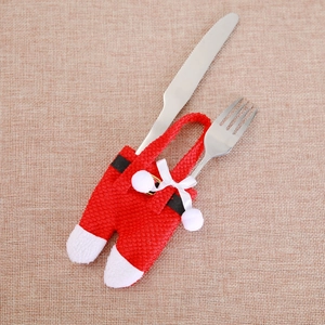 Detailed view of Santa pants cutlery holders with white bows on a rustic burlap background