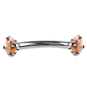 Close-up of silver curved barbell with vibrant orange cubic zirconia for eyebrow piercing