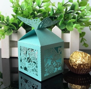 Detailed laser-cut wedding favor box in light turquoise with butterfly top ornament
