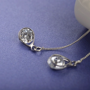 Boucles d'oreilles pampilles argentées avec zircon sur fond bleu foncé profond