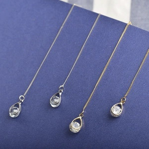 Détail de boucles d'oreilles pampilles en zircon en forme de goutte d'eau or et argent
