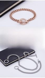 Dettaglio dei bracciali a maglia cubana in oro rosa e argento con chiusura OT glitterata