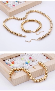 Dettaglio del set collana e bracciale con perline dorate e chiusura su conchiglie