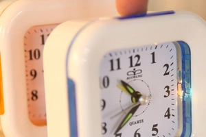 Close-up of square plastic alarm clocks in white with blue and orange border accents