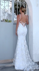 Detail of cross back straps and floral lace pattern on white mermaid evening dress