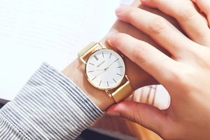Close-up of minimalist gold Milanese mesh strap quartz watch on a male model wrist