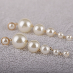 Elegant long drop earrings featuring six cascading white pearls with golden finish
