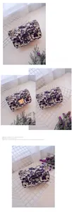 Detail of a purple graffiti heart print crossbody bag with gold chain strap and lock