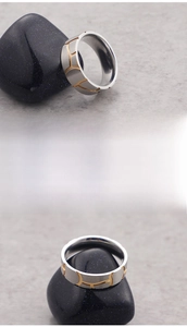 Detail view of titanium steel ring with gold geometric textures and fine steel engraving
