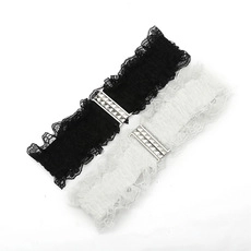 Detailed view of black and white lace garters featuring silver riveted metal bars