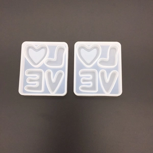 Macro shot of two-piece square silicone mold with heart and letter shapes for DIY resin art