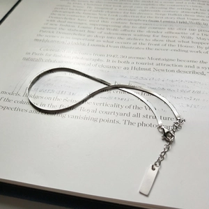 Detailed view of an S925 sterling silver blade chain anklet placed on an open book page