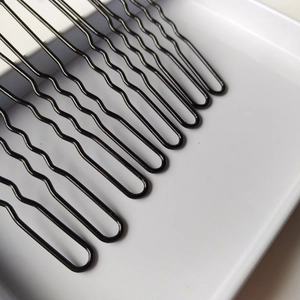 Série d'épingles à cheveux ondulées en métal noir en forme de U sur plateau blanc