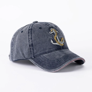 Detail of nautical anchor embroidery and washed denim texture on baseball cap