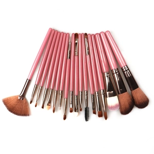 Detailed set of 17 pink and rose gold makeup brushes arranged on white background