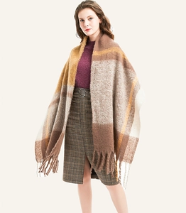Detail shot of oversized plaid scarf with thick tassels in warm brown and yellow tones