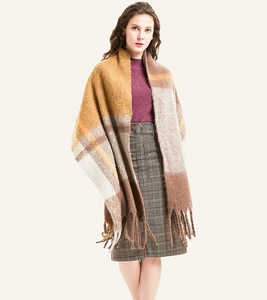 Close-up of mustard yellow and camel plaid scarf with thick tassels and soft knit texture