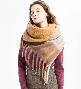 Close-up detail of oversized thick tassel scarf in brown and yellow mohair pattern