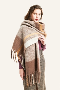 Detail of soft thick tassel edges on brown beige plaid oversized knit shawl scarf