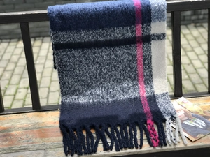 Close-up of thick plaid knit scarf with pink and blue checks and fringe details