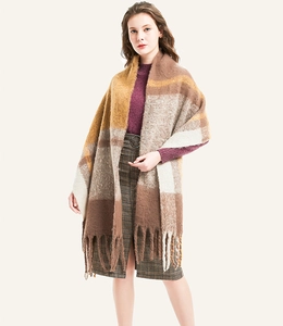 Detail of soft thick plaid scarf with tassels in brown beige and mustard yellow