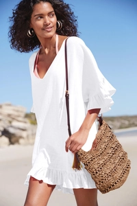 Detalle del vestido playero blanco con volantes y textura de tela de algodón de calidad