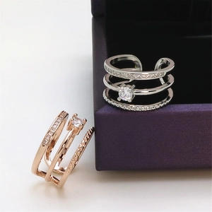 Close-up of silver and rose gold triple-layered rings with sparkling stones in a box