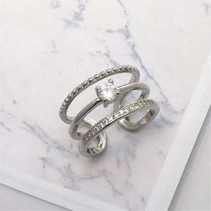 Detailed close-up of a triple-layered silver open ring with sparkling cubic zirconia accents