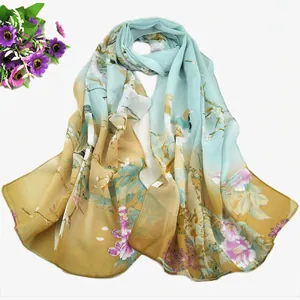 Detail of light green and khaki chiffon scarf featuring floral and bird pattern
