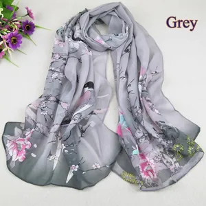 Close-up of floral and bird print on semi-transparent grey chiffon scarf for women