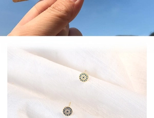 Detailed close-up of evil eye round stud earrings featuring blue and white crystals