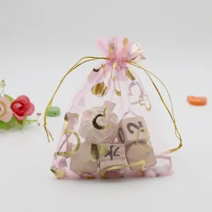 Detail of pink organza gift bag featuring gold stamped hearts and drawstring closure