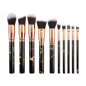 Detail of 10-piece makeup brush set with black marble handles and gold ferrules on white