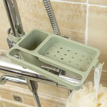 Green plastic drainage rack mounted on faucet for holding soaps and sponges in showers