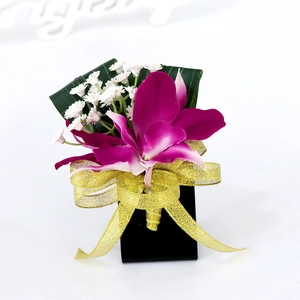 Boutonnière formal de orquídea artificial con pétalos de color magenta y cinta dorada decorativa