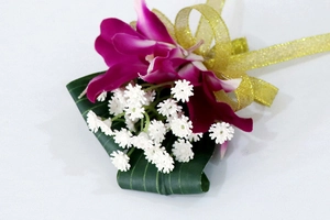 Primer plano de un ramillete de orquídea púrpura con flores blancas y lazo dorado