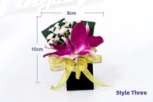 Detail of dark purple orchid corsage with gold ribbon and dimensions 9cm by 10cm