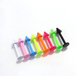Macro shot of stainless steel colorful cone lip studs and ear cartilage piercings